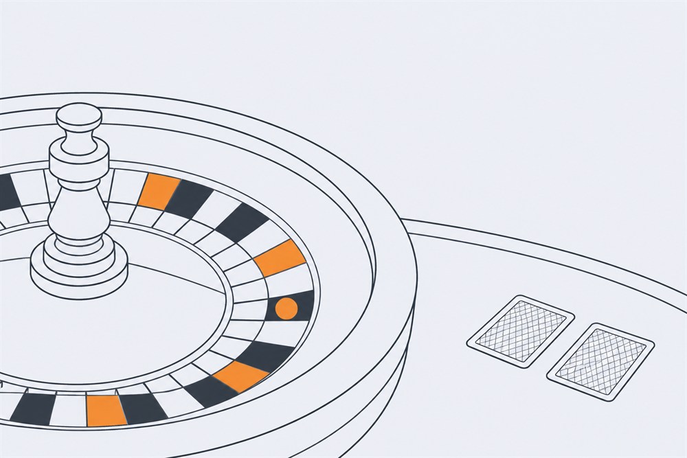 Detail of a roulette wheel rim with a ball resting in one pocket, beside two face-down playing cards on a table edge